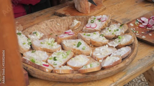 slices of bread with lard grease and spring onion served on a carved wooden plate