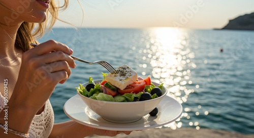 Close-up of a woman eating a Greek salad by the seaside, sunlight reflecting on water, fresh ingredients like olives and feta cheese visible, wind in her hair, relaxed vacation atmosphere