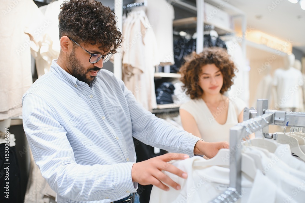 Obraz premium Arab couple choosing clothes in fashion store