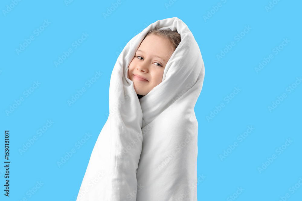 Little girl wrapped in blanket on blue background Little girl wrapped in blanket on blue background