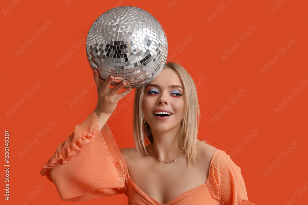 Naklejka premium Beautiful young woman with disco ball on red background