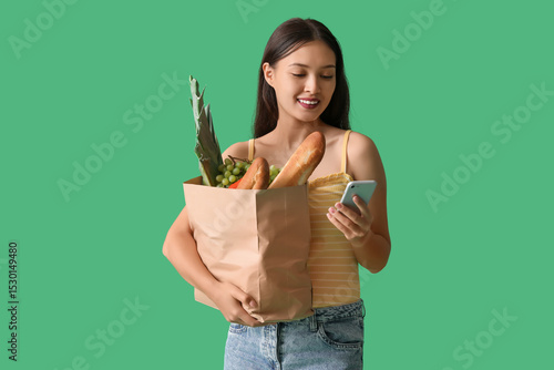 Young Asian woman with mobi...