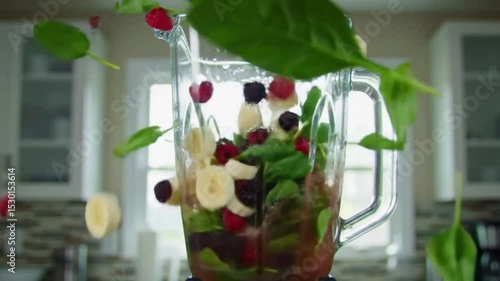 A vibrant close-up of a blender full of fresh fruits and greens for a smoothie.