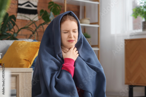 Sick young woman wrapped in...