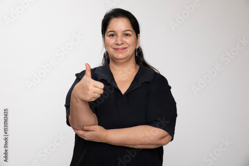 Indian matured chubby woman with thumbs on grey background