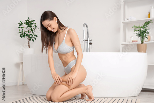 Young woman massaging her l...