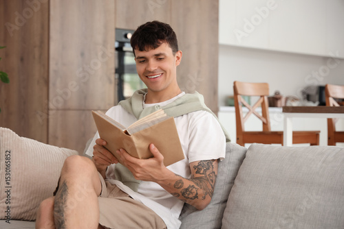 Young man reading book on s...
