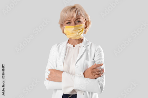 Female doctor in medical mask on white background