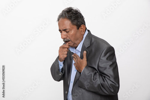 Obraz na plátně Portrait of  unhealthy senior corporate man with grey hair standing over isolated grey studio background feeling unwell and coughing as symptom for cold or bronchitis