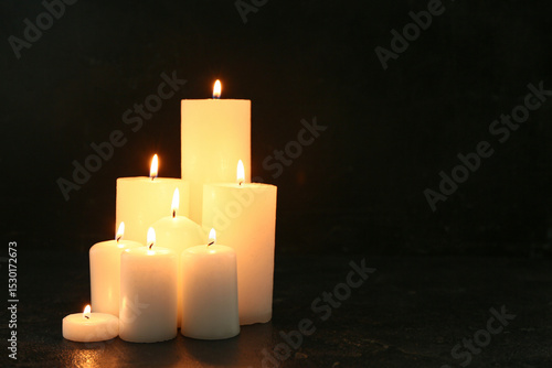 Burning candles on black ba...