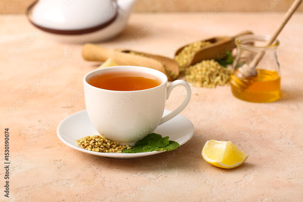 Cup of hot buckwheat tea with lemon slice and mint leaves on beige grunge background Cup of hot buckwheat tea with lemon slice and mint leaves on beige grunge background
