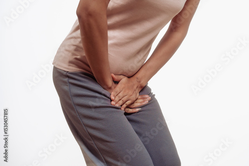 Wallpaper Mural Confident young Asian woman in light brown shirt stands against a white background, experiencing vaginal pain. inflammation, cysts, endometriosis gynecological conditions affecting female health. Torontodigital.ca