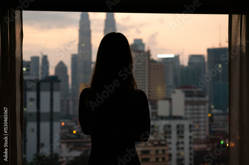 Canvas Print Silhouette of woman at sunset with city skyline