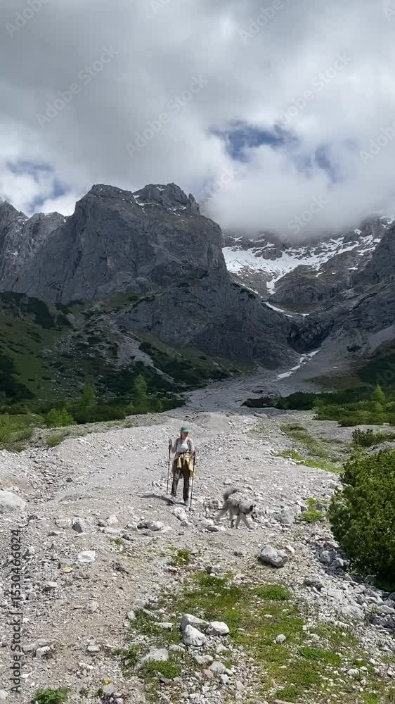 Woman hiking with dog in the Dachstein Alps Mountains Woman hiking with dog in the Dachstein Alps Mountains