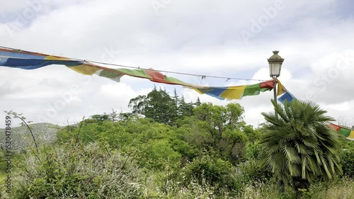 prayer flags flutter in the wind at a buddhist monastery in garraf spain