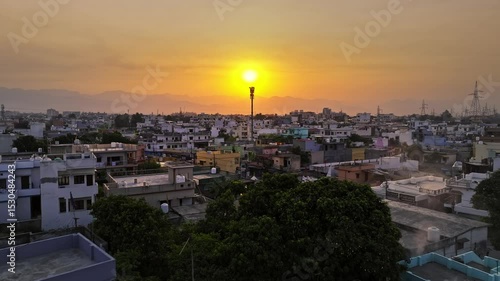An aerial view of the picturesque city of Dehradun in Uttarakhand, India, captured during a breathtaking sunrise. The cinematic shot showcases the city's blend of urban charm and natural beauty.