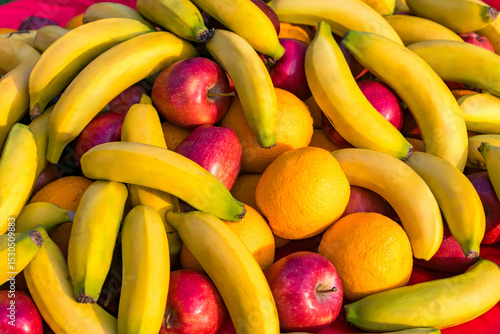 Juicy and bright fruits - bananas, red apples and oranges lie on the open-air buffet