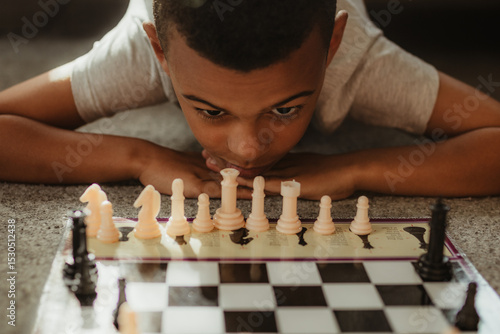 Young boy playing chess and concentrating