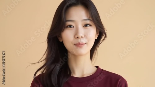 Asian Woman Nods Approvingly on Beige Background