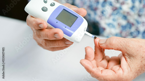 Photos Blood glucose meter diabetes test elderly hand checking blood sugar healthcare medical device monitoring finger prick close up home test health awareness