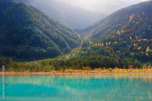 Autumn landscape with turquoise water, forest and mountain in the Pyrenees of Spain on a sunny day