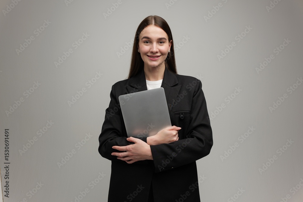 Confident Young Woman Poses With a Laptop in a Modern Studio Setting Amidst a Neutral Backdrop, Showcasing Her Professional Style and Warmth Confident Young Woman Poses With a Laptop in a Modern Studio Setting Amidst a Neutral Backdrop, Showcasing Her Professional Style and Warmth