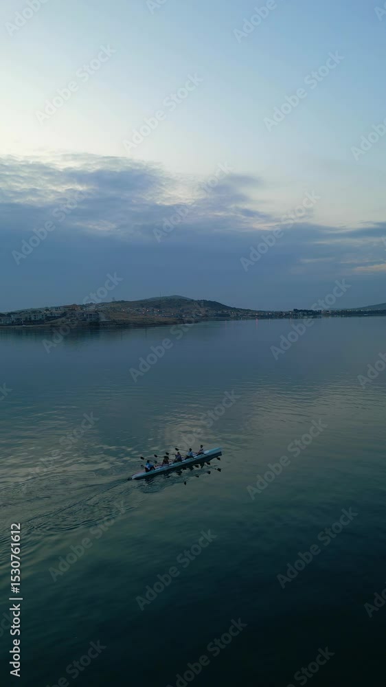 Sport Canoe with a team of four people rowing on tranquil water, Aerial view. High quality 4k footage Sport Canoe with a team of four people rowing on tranquil water, Aerial view. High quality 4k footage