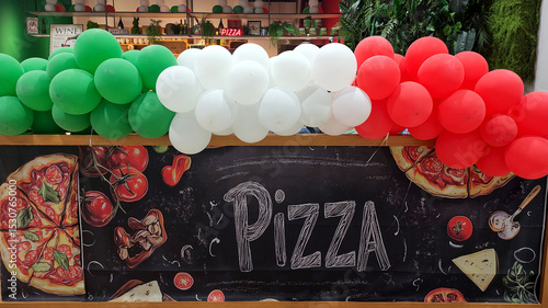 Warsaw, Poland - June 10, 2025: Colorful pizza stall with Italian flag balloons and vibrant decorations