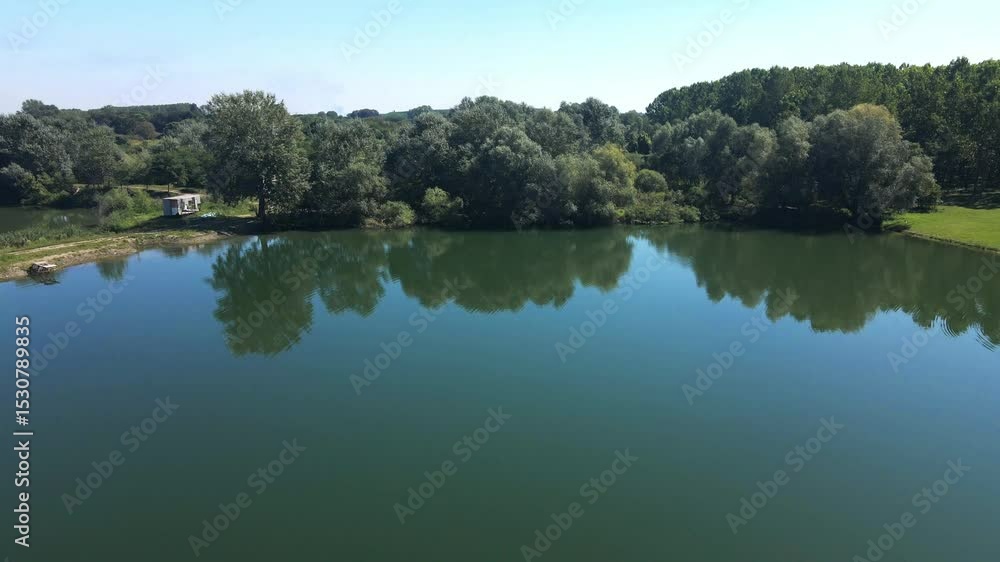 Peaceful afternoon at Ivanovacka ada, Serbia with tranquil waters and lush greenery Peaceful afternoon at Ivanovacka ada, Serbia with tranquil waters and lush greenery