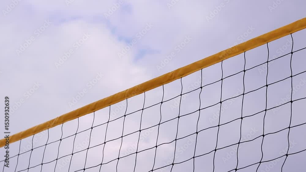Beach volleyball net close-up. Volleyball net fragment on the beach against the sky. Sport, beach volleyball. Active recreation concept. Background. Yellow net detail. Sports ground Beach volleyball net close-up. Volleyball net fragment on the beach against the sky. Sport, beach volleyball. Active recreation concept. Background. Yellow net detail. Sports ground