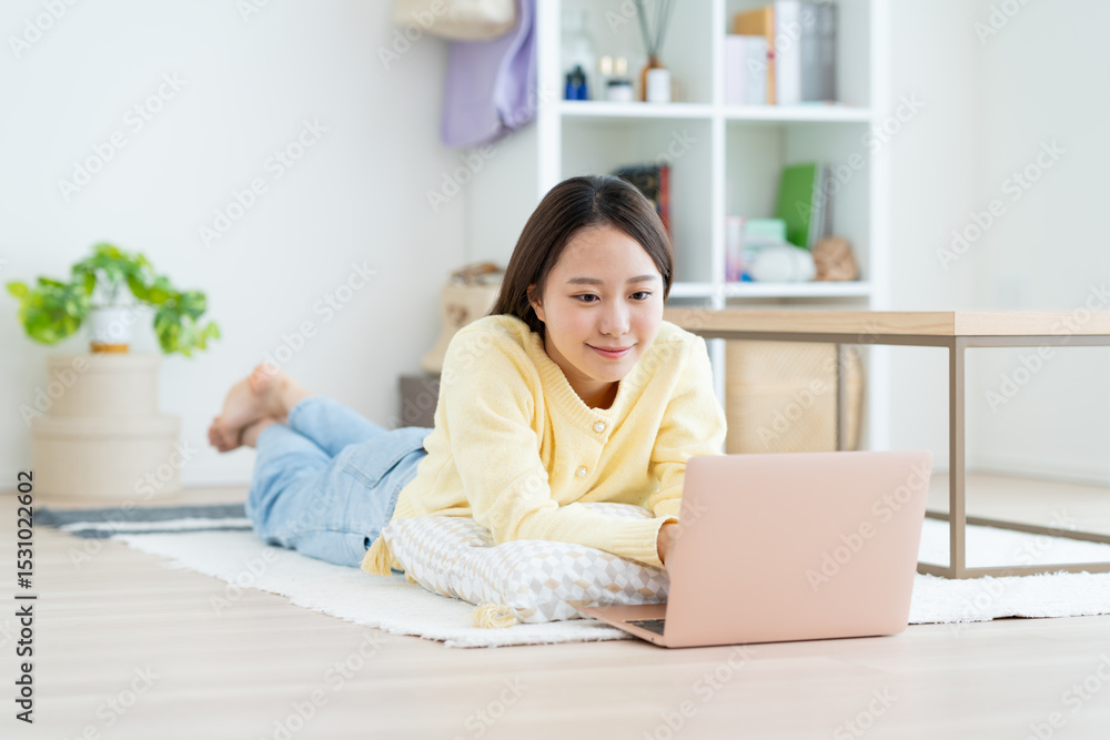 リビングでパソコンを使う若い女性 リビングでパソコンを使う若い女性