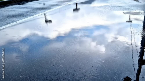 Reflective Puddle Surface with Sky and Streetlight Reflections After Rainfall
