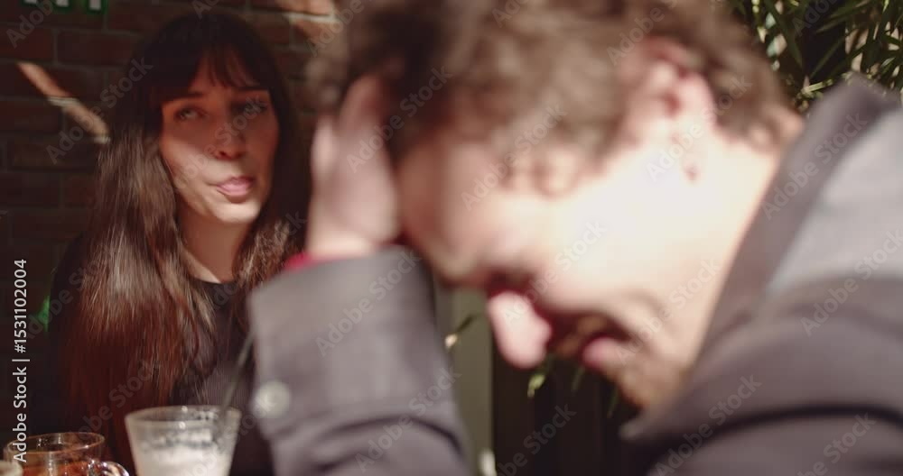 Couple making various facial expressions at each other in a restaurant during the daytime. They are having a discussion. Couple making various facial expressions at each other in a restaurant during the daytime. They are having a discussion.
