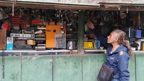 Tableau sur toile An Asian man or father is browsing at a second-hand market for antique goods