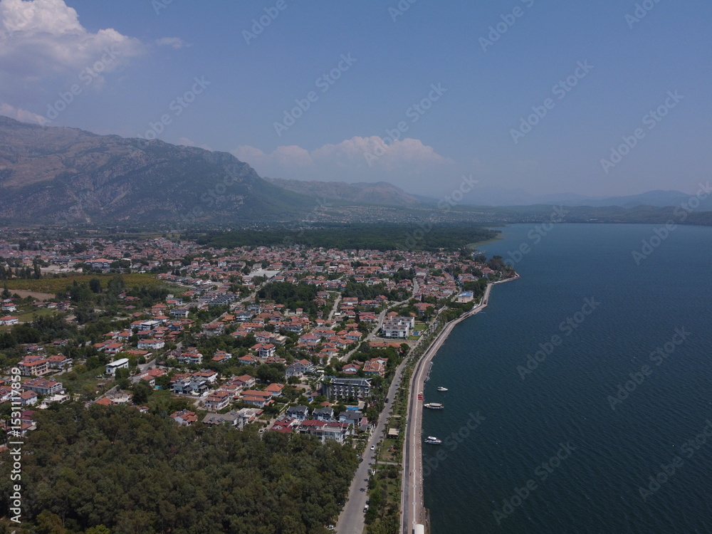 Fototapeta premium A serene aerial view of Lake Köyceğiz in Turkey on a calm summer day, showcasing tranquil blue waters, lush surroundings, and peaceful natural beauty.