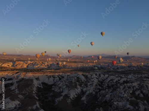 Wallpaper Mural A magical drone shot of sunrise over Göreme as colorful hot air balloons lift off, painting the sky above the surreal Cappadocian landscape in golden light. Torontodigital.ca