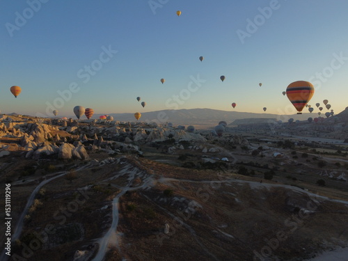 Wallpaper Mural A magical drone shot of sunrise over Göreme as colorful hot air balloons lift off, painting the sky above the surreal Cappadocian landscape in golden light. Torontodigital.ca