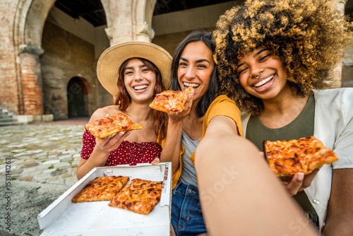 Photography Three multiracial women eating pizza in city street - Smiling female friends tak
