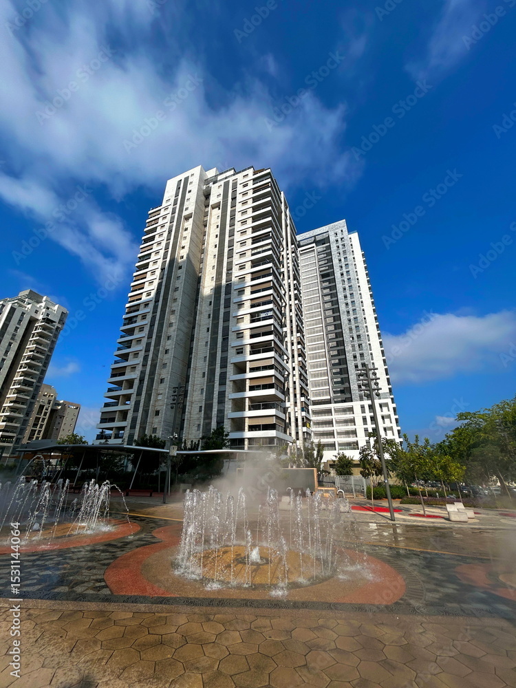 Obraz premium Fountain in the middle of a modern residential area. Multi-storey apartment buildings, Israeli city. Comfortable housing