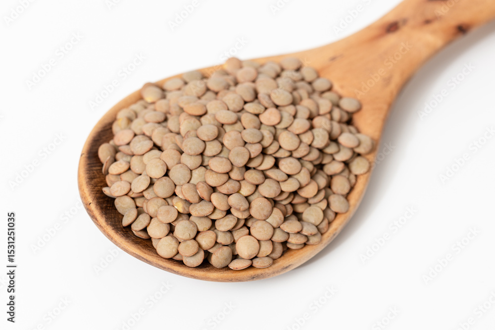 Close-up of a wooden spoon with brown lentils isolated on white background Close-up of a wooden spoon with brown lentils isolated on white background