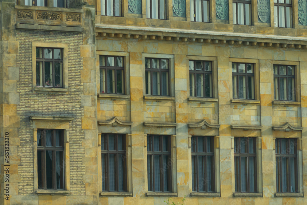 Fototapeta premium The impressive facade of the majestic stone building features elegant windows and intricate details, capturing the essence of urban design and showcasing its historic charm