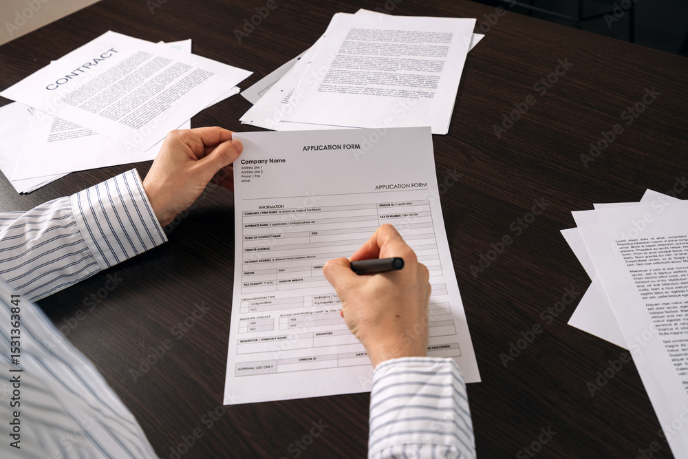 Obraz premium Filling out an application form on the office desk with important paperwork nearby