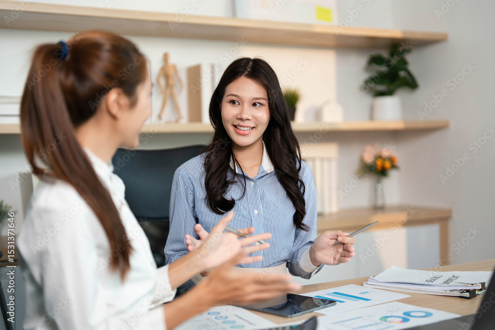 Dynamic Team Collaboration. Two women engaging in financial discussions at their workplace. Dynamic Team Collaboration. Two women engaging in financial discussions at their workplace.
