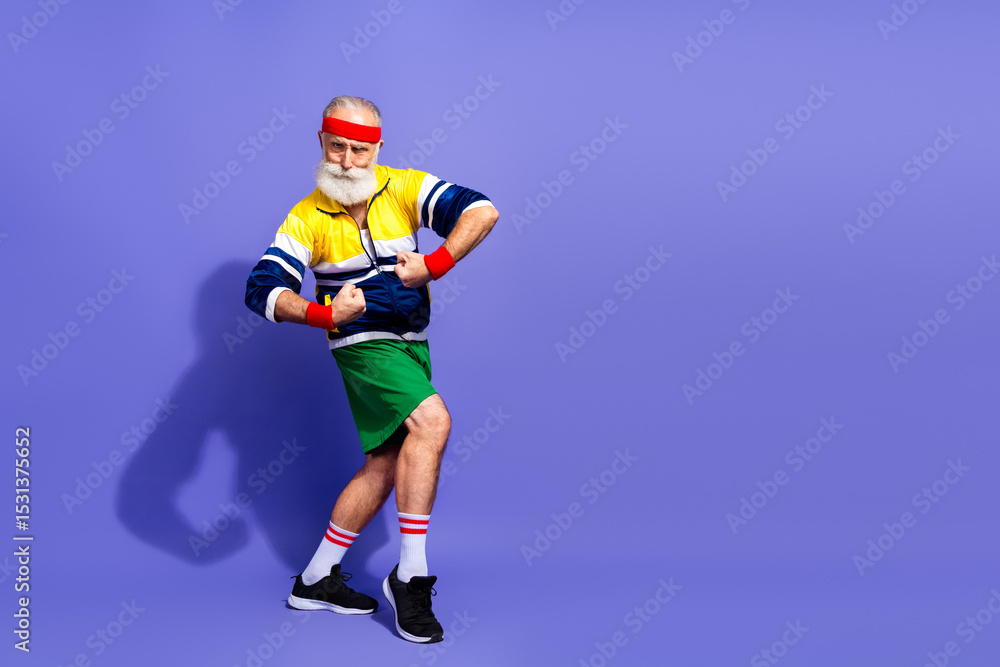 Elderly man in retro athletic wear posing for fitness and humor concept on vibrant colorful studio background Elderly man in retro athletic wear posing for fitness and humor concept on vibrant colorful studio background