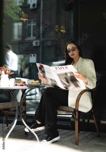 Elegant woman reading newspaper at coffee shop
