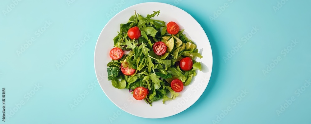 Fresh green salad with cherry tomatoes served on a white plate against a light blue background. Fresh green salad with cherry tomatoes served on a white plate against a light blue background.