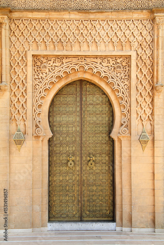 Morocco, Rabat, typical old arabesque intricate engraved brass door and surround in sandstone  sculpted in detailed Islamic design.