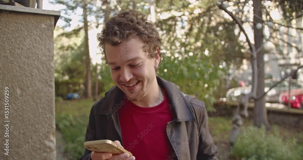 Man reacts with various facial expressions as he looks at his phone. He's standing outside in his yard on a sunny day. Man reacts with various facial expressions as he looks at his phone. He's standing outside in his yard on a sunny day.