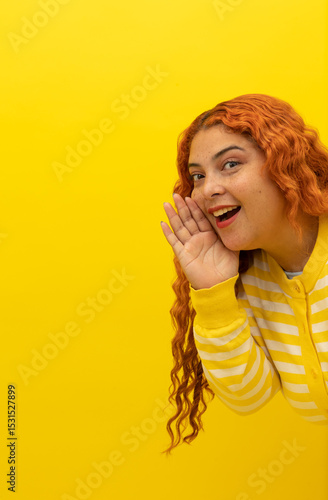 Obraz na plátne Vertical image of a freckled red haired woman wearing a yellow, white striped sh