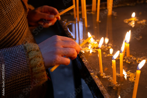 Fotografie woman lighting candles in church